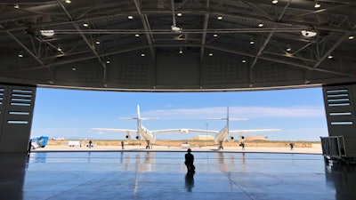 In this Aug. 15, 2019 file photo, Virgin Galactic ground crew guide the company's carrier plane into the hangar at Spaceport America following a test flight over the desert near Upham, New Mexico. Virgin Galactic Holdings Inc. has agreed to a deal with NASA to boost commercial human spaceflight to the International Space Station and develop a “robust economy” in space.