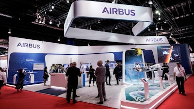 In this Tuesday, Feb. 11, 2020 file photo, visitors are seen at the booth of Airbus during the opening trade day of the Singapore Airshow 2020 in Singapore. European aircraft manufacturer Airbus says it plans to shed 15,000 jobs over the next year, with jobs mostly being lost in Europe. Airbus is struggling with the financial hit of the coronavirus pandemic. It said Tuesday, June 30 that it doesn't expect air traffic to recover to pre-COVID levels before 2023 and potentially as late as 2025.