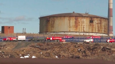 In this image taken from video provided by the RU-RTR Russian television on Wednesday, June 3, 2020, Russian Emergency Situations Ministry trucks work at the scene of an oil spill at a power plant in an outlying section of the city of Norilsk, 2900 kilometers (1800 miles) northeast of Moscow, Russia. Russian President Vladimir Putin has declared a state of emergency in a region of Siberia after an estimated 20,000 tons of diesel fuel spilled from a power plant storage facility and fouled waterways.