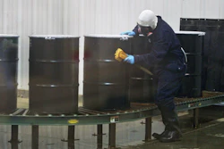 A worker decontaminates steel drums containing yellowcake uranium at UR Energy's Lost Creek facility, Sweetwater Co., Wyo., Dec. 9, 2013.