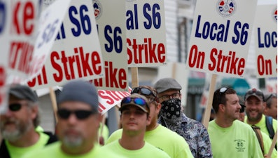 Striking shipbuilders picket outside an entrance to Bath Iron Works.