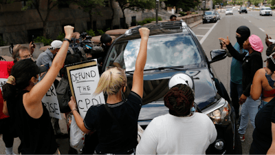 Protestors block a car with Ohio House Speaker Larry Householder.