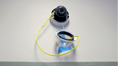 A camera with facial recognition capabilities hangs from a wall during installation at Lockport High School in Lockport, N.Y., July 10, 2018.