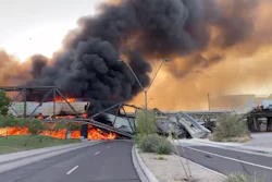 Smoke fills the sky at the scene of a train derailment.