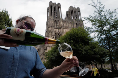 A waitress serves a glass of champagne at La Grande Georgette restaurant in front of the cathedral in Reims, the Champagne region, east of Paris on July 28.