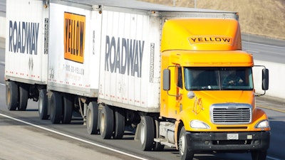 In this Feb. 2, 2010, file photo, a Yellow Freight/Roadway Express truck travels east on I-70, near Lecompton, Kan. The struggling trucking company once sued by the Department of Defense is getting a $700 million loan from the U.S. government because it is “critical to maintaining national security,” the Treasury Department said Wednesday, July 1, 2020. U.S. taxpayers will take a 29.6% stake in YRC Worldwide as a result of the deal, which was made as part of the Coronavirus Aid, Relief, and Economic Security Act.