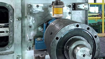 A Greasomatic lubricates a conveyor tail pulley bearing.