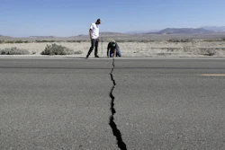 Ron Mikulaco, right, and Brad Fernandez examine a crack caused by an earthquake on Highway 178 outside Ridgecrest, Calif., July 6, 2019.