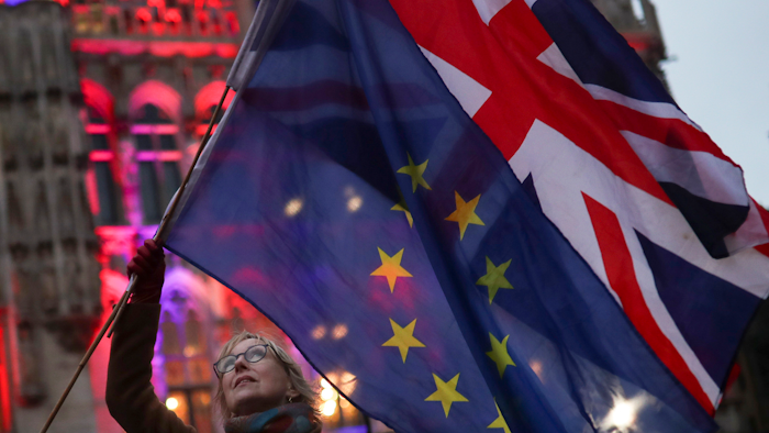 A woman holds the British and European Union flags during an event in Brussels, Jan. 30, 2020.