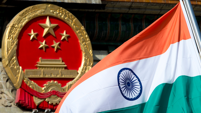 An Indian flag is flown next to the Chinese national emblem outside the Great Hall of the People, Beijing, Oct. 23, 2013.