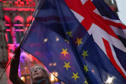 A woman holds the British and European Union flags during an event in Brussels, Jan. 30, 2020.
