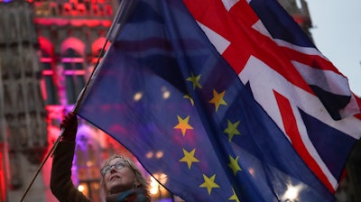 A woman holds the British and European Union flags during an event in Brussels, Jan. 30, 2020.