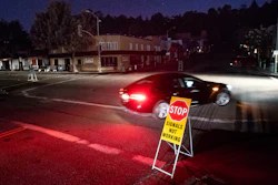 A car drives through a darkened Montclair Village.