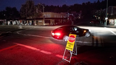 A car drives through a darkened Montclair Village.