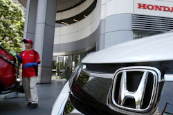 Employee of Honda Motor Co. cleaning a Honda car displayed at its headquarters in Tokyo.