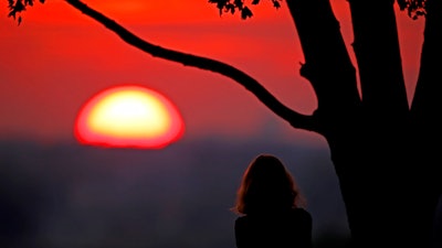 In this July 3, 2020, file photo, a woman watches the sunset from a park in Kansas City, Mo. 2020 is barely halfway over. The Great Recession inspired many money lessons that are relevant for the current coronavirus-related economic downturn. If you’re feeling financially squeezed by the pandemic, explore actions that experts have suggested and taken to overcome obstacles in the previous financial crisis.