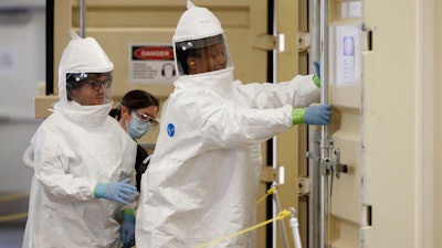 In Colorado, where there is a shortage of PPE, workers prepare to enter an N95 mask-cleaning machine.