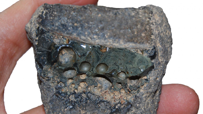 Crucible slag adhering to the interior of a crucible sherd.