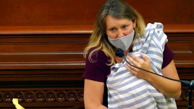 Assemblywoman Buffy Wicks, a Democrat from Oakland, addresses lawmakers while holding her one-month-old daughter Elly in her arms during the final hours of the California legislative session in Sacramento, Calif.