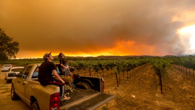 In this Aug. 20 photo, Thomas Henney, right, and Charles Chavira watch a plume spread over Healdsburg, CA as the LNU Lightning Complex fires burn.