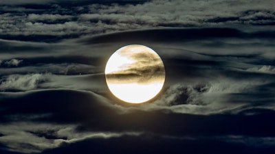 In this Sept. 2, 2020 file photo, the full moon shines surrounded by clouds in the outskirts of Frankfurt, Germany.