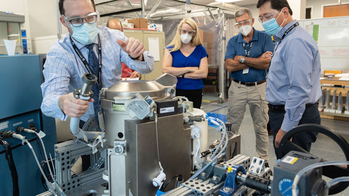In this June 18, 2020 photo provided by NASA, astronaut Kate Rubins, center, and support personnel review the Universal Waste Management System, a low-gravity space toilet, in Houston. The new device is scheduled to be delivered to the International Space Station on Oct. 1, 2020.