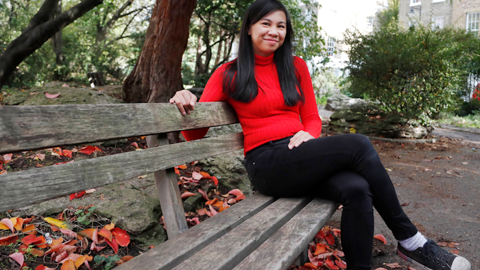 Danica Marcos, sits in a park in London, Friday, Oct. 16, 202. Danica Marcos a volunteer as U.K. researchers are preparing to begin a controversial experiment that will infect healthy volunteers with the new coronavirus to study the disease in hopes of speeding up development of a vaccine.