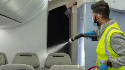 A test team member sprays a disinfectant over areas where the MS2 virus was applied.