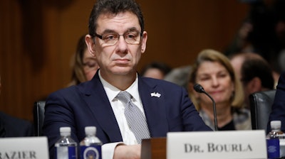 In this Tuesday, Feb. 26, 2019 file photo, Albert Bourla, chief executive officer of Pfizer, prepares to testify before the Senate Finance Committee hearing on drug prices, on Capitol Hill in Washington. On Thursday, Oct. 1, 2020, Bourla wrote to Pfizer employees that he's “disappointed” the timing for a vaccine to be available was politicized during Tuesday night’s presidential debate, saying the company won’t succumb to political pressure.