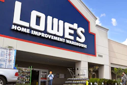 Customers wearing masks walk into a Lowe's home improvement store.