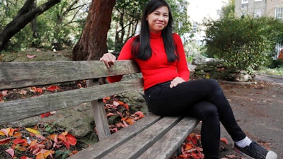 Danica Marcos, sits in a park in London, Friday, Oct. 16, 202. Danica Marcos a volunteer as U.K. researchers are preparing to begin a controversial experiment that will infect healthy volunteers with the new coronavirus to study the disease in hopes of speeding up development of a vaccine.