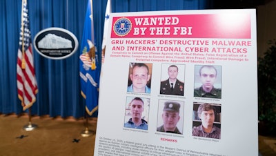 A poster showing six wanted Russian military intelligence officers at the Department of Justice, Oct. 19, 2020, Washington.