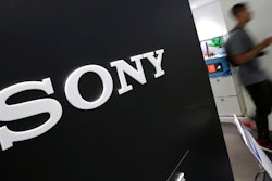 Visitors walk past a logo of Sony at Sony Building in Tokyo.
