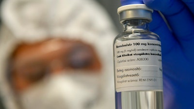 A bottle containing the drug Remdesivir is shown by a health worker at the Institute of Infectology of Kenezy Gyula Teaching Hospital of the University of Debrecen in Debrecen, Hungary, Thursday Oct. 15, 2020. The drug developed by the Budapest based Chemical Works of Gedeon Richter Plc., is administered to novel coronavirus patients in serious condition as a clinical test to stop the replication of the virus.