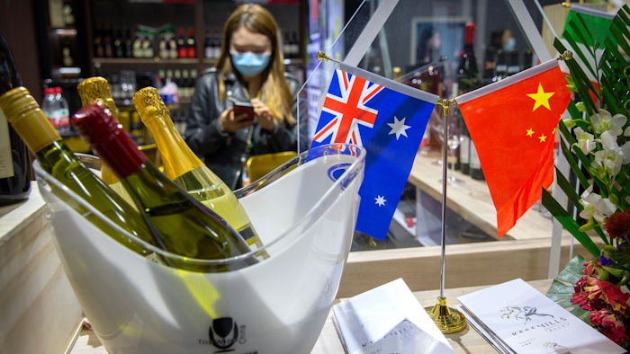 A staff member wearing a face mask stands near a display of Australian wines at the China International Import Expo in Shanghai on Nov. 5.