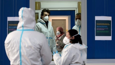 A medical workers works in a COVID-19 set up for rapid new coronavirus testing in Vienna, Austria on Monday, Nov. 30.