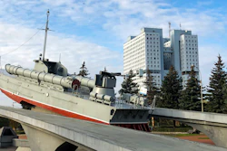 The building and the torpedo boat, the Baltic Sailors Memorial, in Kaliningrad, Russia, Thursday, Oct. 29, 2020. The hulking never-occupied building sardonically likened to a robot's head that has loomed over the city of Kaliningrad for decades is to be demolished next year, the region's governor says. The 21-story House of Soviets was left unfinished when funding ran out in 1985 amid the Soviet Union's economic struggles and later was assessed to be structurally unsound.