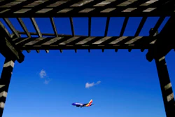 A shelter is seen at the Thomas Dixon Aircraft Observation Area as a Southwest Airlines flight from Jacksonville, Fla., makes its landing approach onto Baltimore-Washington International Thurgood Marshall Airport, Monday, Nov. 23, 2020, in Glen Burnie, Md. With coronavirus cases spiking in the U.S. and Europe, the financial outlook of the world's airlines is getting worse. The International Air Transport Association said Tuesday that around the world, airlines will lose more than $157 billion this year and next.