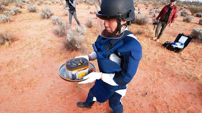 JAXA staff member retrieves a capsule dropped by Hayabusa2 in Woomera, Australia, Dec. 6, 2020.