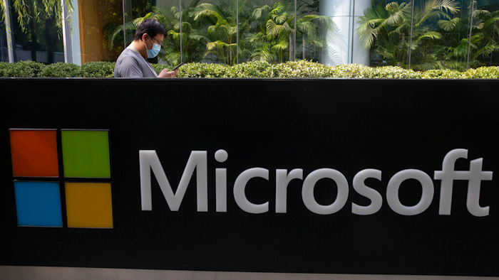 A man wearing a mask looks at this phone outside the Microsoft office in Beijing.