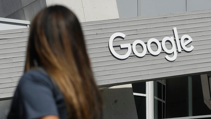 In this Sept. 24, 2019, file photo a woman walks below a Google sign on the company's campus in Mountain View, Calif. A group of Google engineers announced Monday, Jan. 4, 2021, they have formed a union, creating a rare foothold for the labor movement in the tech industry.