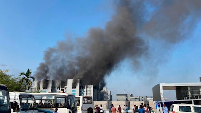 Smoke rises from the Serum Institute of India, the world's largest vaccine maker that is manufacturing the AstraZeneca/Oxford University vaccine for the coronavirus, in Pune, India, Thursday, Jan. 21, 2021.