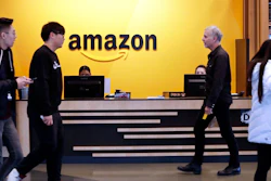 In this Nov. 13, 2018, file photo, employees walk through a lobby at Amazon's headquarters in Seattle. Amazon has announced $2 billion in loans and grants to secure affordable housing in three U.S. cities, including a Seattle suburb where the online retail giant employs at least 5,000 workers. Amazon said it would give $185.5 million to the King County Housing Authority to help buy affordable apartments in the region and keep the rents low, The Seattle Times reported Wednesday, Jan. 6, 2021.