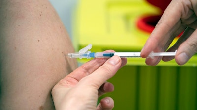A member of staff at the university hospital injects the Moderna vaccine against COVID-19 into a patient in Duesseldorf, Monday, Jan. 18, 2021.