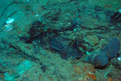 This 2004 photo provided by the Institute for Exploration, Center for Archaeological Oceanography/University of Rhode Island/NOAA Office of Ocean Exploration, shows the remains of a coat and boots in the mud on the sea bed near the Titanic's stern. Fallout from the coronavirus pandemic is threatening a company’s plans to retrieve and exhibit the radio that had broadcast distress calls from the sinking vessel, according to a court filing made by the firm on Monday, Jan. 11, 2021.