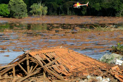 Rescue workers in a helicopter search a flooded area after a dam collapsed in Brumadinho, Brazil, Jan. 27, 2019.