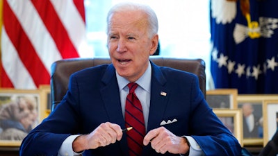 In this Jan. 28, 2021 file photo, President Joe Biden signs a series of executive orders in the Oval Office of the White House in Washington.