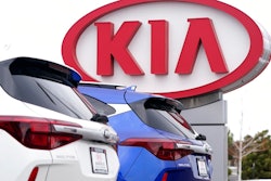 In this Sunday, Dec. 20, 2020, file photo the company sign stands over a row of unsold 2021 Seltos models at a Kia dealership, in Centennial, Colo. Kia Motors America says it’s restoring services crippled by a computer network outage that began Saturday, Feb. 13, 2021, and which apparently affected dealers’ ability to order vehicles and parts and knocked offline a smartphone app that owners use to remotely start and warm up vehicles.