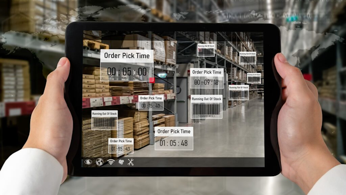 Person holding iPad looking at warehouse.