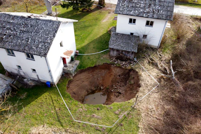 This aerial photo shows a sinkhole in the village of Mececani, central Croatia, Thursday, March 4, 2021. A central Croatian region about 40 kilometers (25 miles) southwest of the capital Zagreb is pocked with round holes of all sizes, which appeared after December's 6.4-magnitude quake that killed seven people and caused widespread destruction. Scientists have been flocking to Mecencani and other villages in the sparsely-inhabited region for observation and study.